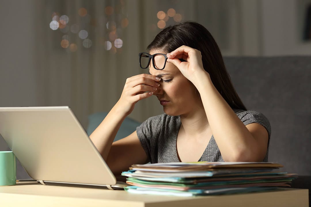 Femme fatiguée s'appuyant contre un mur