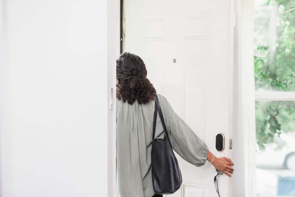 Jeune femme quittant une maison, visiblement perturbée