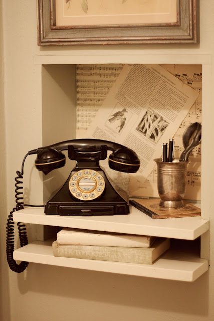 Ancien téléphone filaire posé sur une étagère en bois