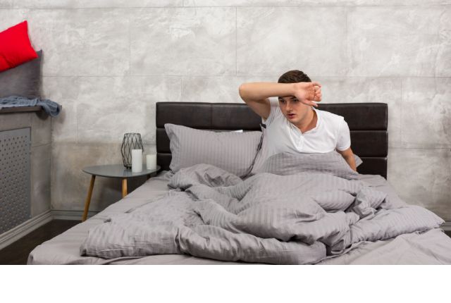 Femme se réveillant en sueur la nuit