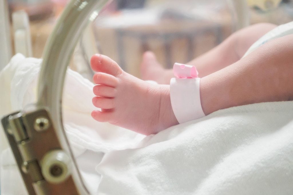 Parents regardant tendrement un nouveau-né en couveuse