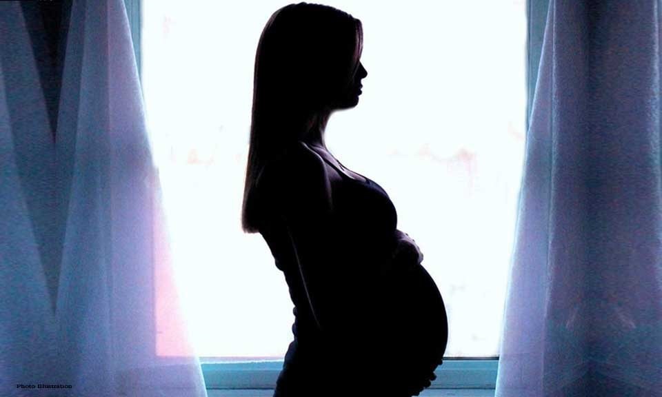 Femme souriante tenant un test de grossesse