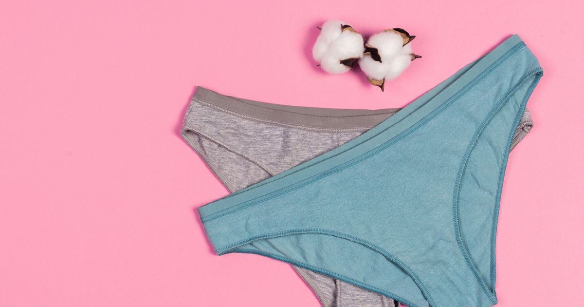 Jeune femme examinant le gousset de sa culotte avec attention