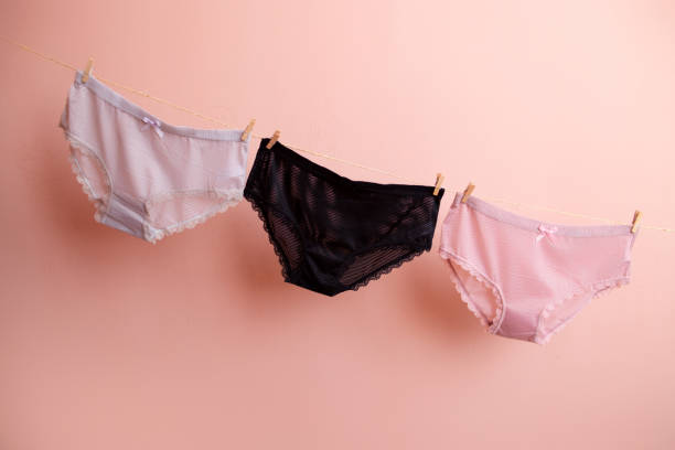 Deux femmes riant devant des étendoirs colorés
