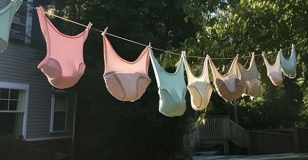 Femme souriante devant un étendoir rempli de lingerie