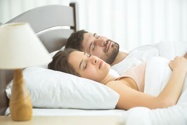 Couple dormant enlacé dans un lit