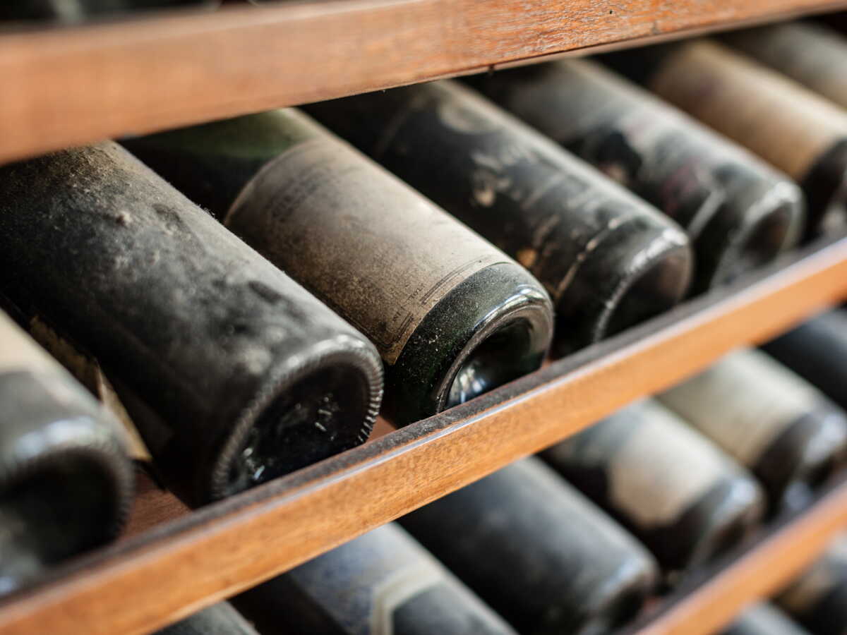 Personne tenant élégamment une bouteille de vin