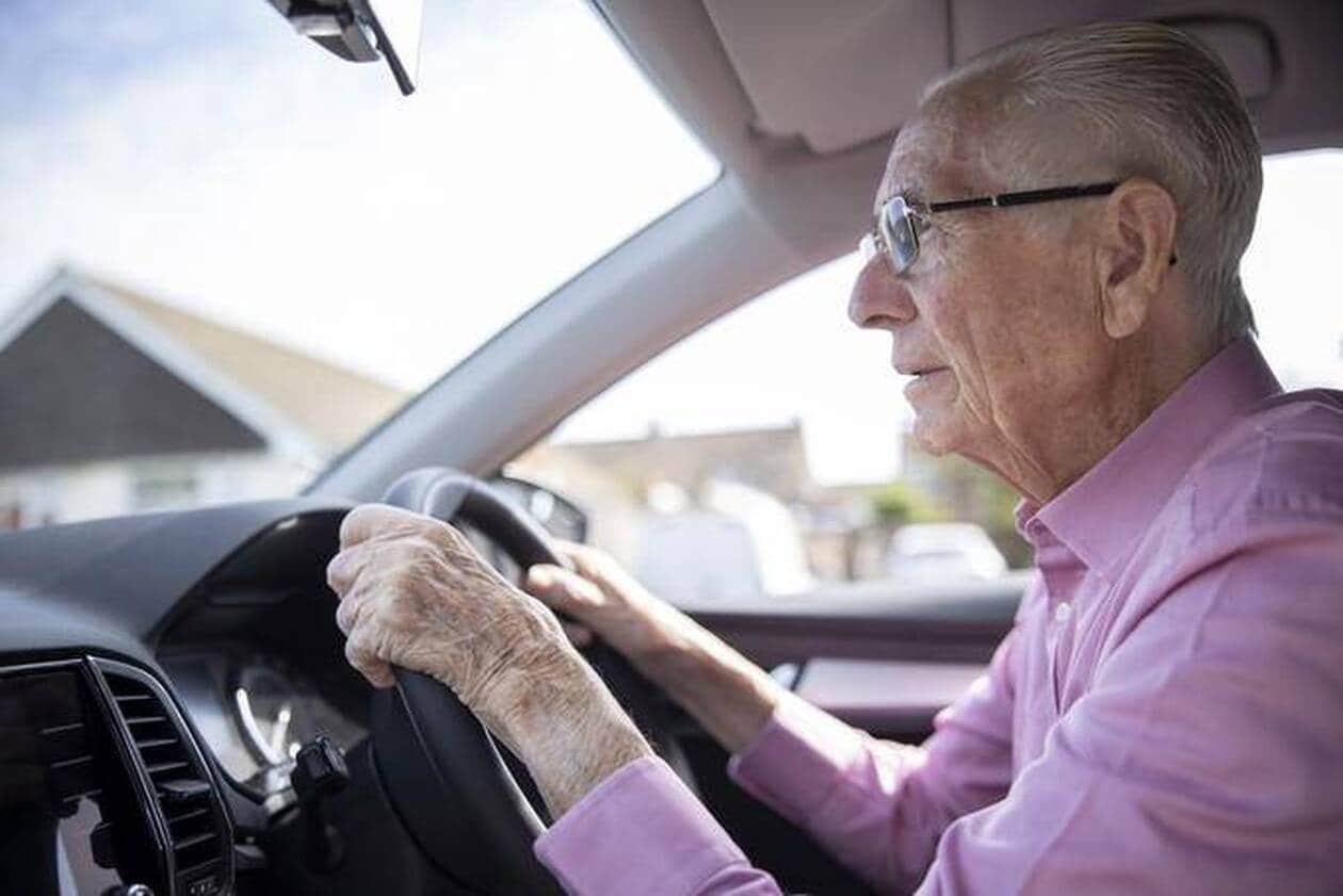 Personne âgée garée devant sa maison