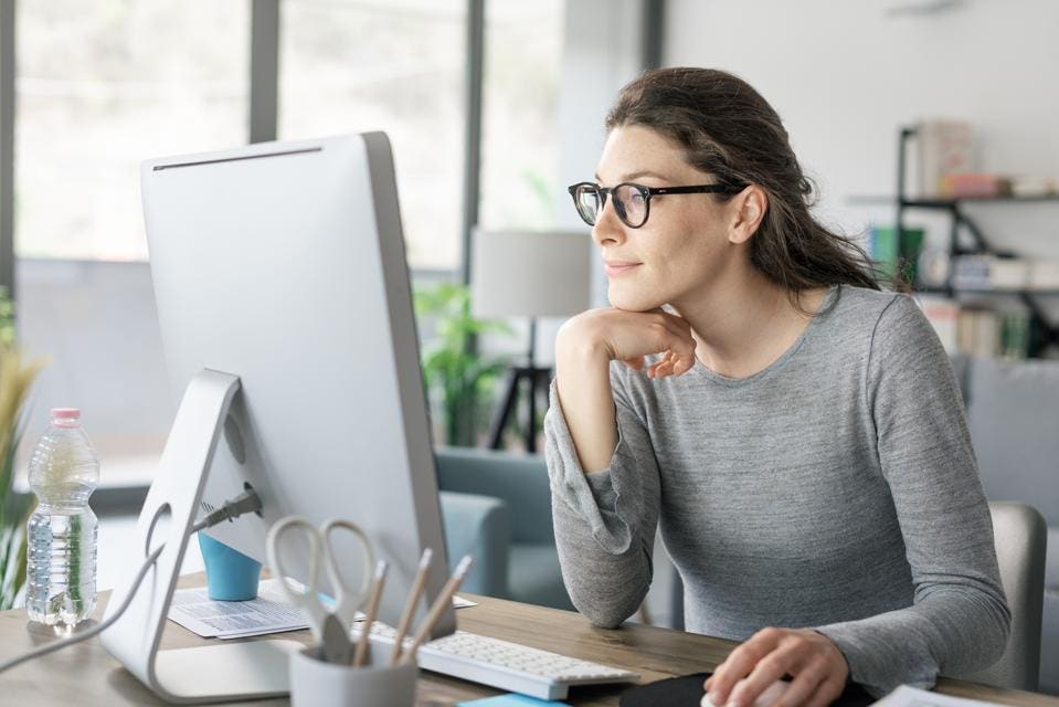 Femme inspirée travaillant sur son ordinateur portable