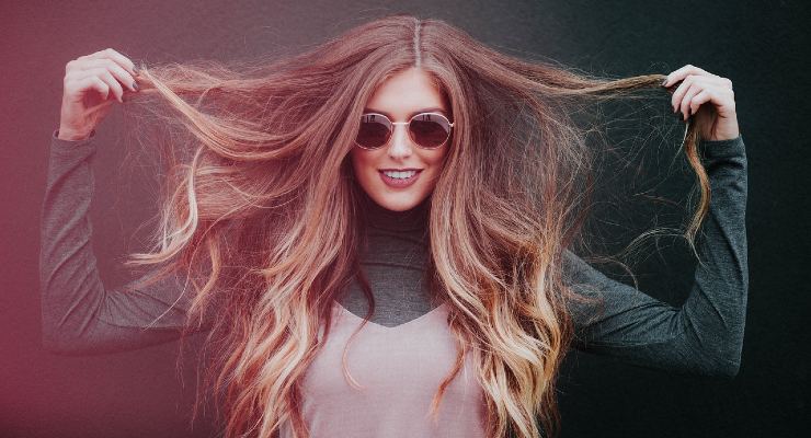 Femme se coiffant avec un peigne et un sèche-cheveux