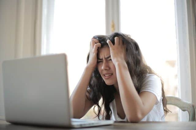 Femme se tenant la tête, manifestant des difficultés de concentration