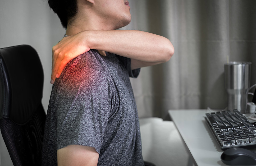 Personne massant son épaule pour soulager une tension musculaire