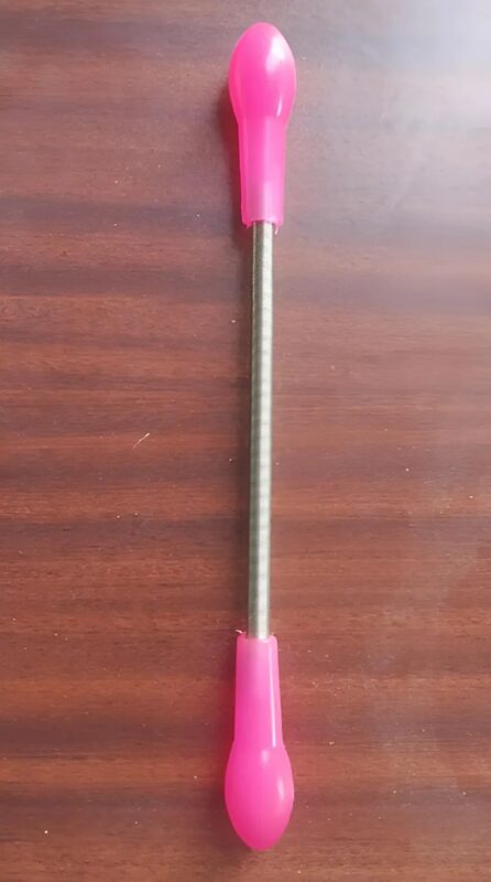 Ressort métallique rose utilisé comme épilateur manuel