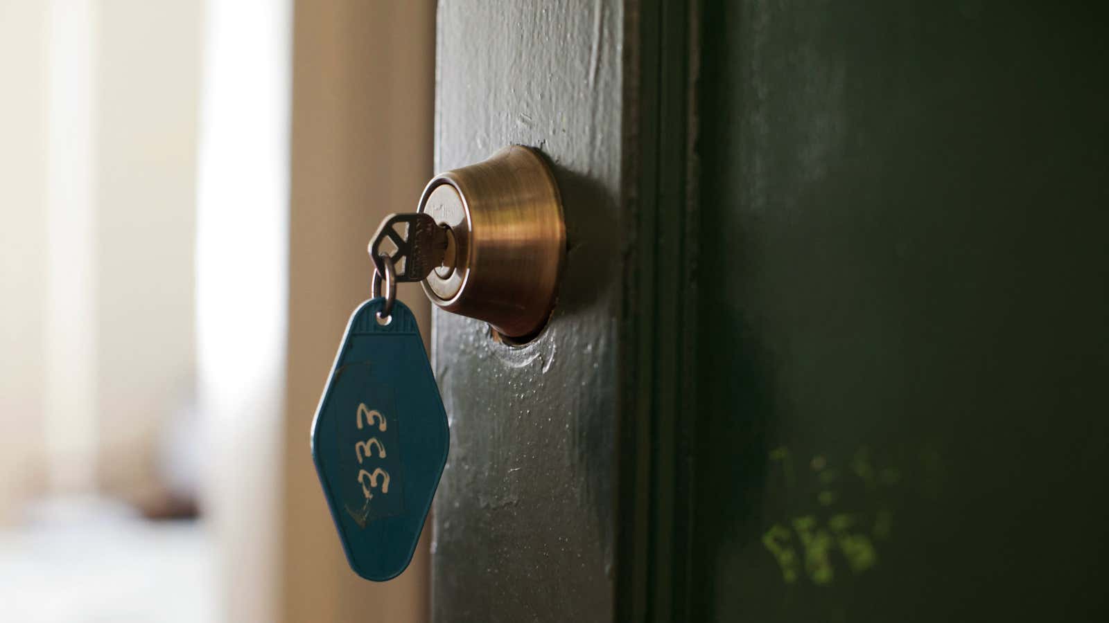 Clé dans une serrure avec une maison éclairée la nuit en arrière-plan