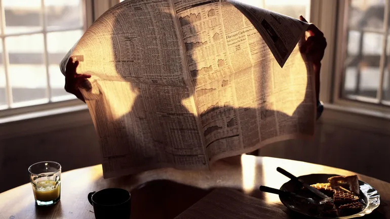 Vieux journal jauni et documents anciens posés sur une table, symbolisant la découverte d'archives.