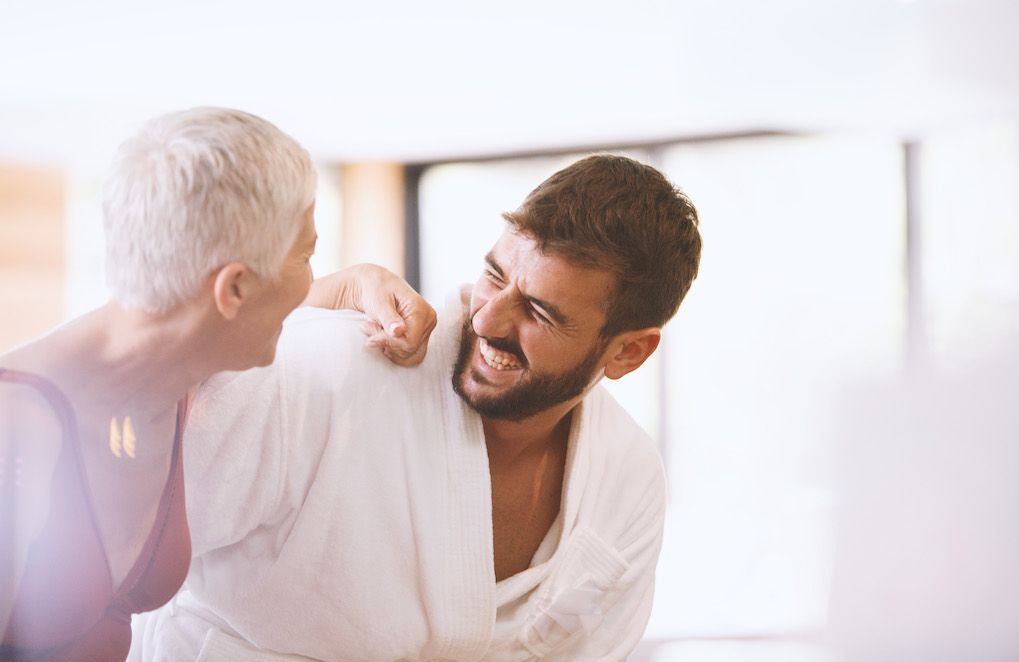 Femme souriante et épanouie discutant avec un homme plus jeune dans un cadre convivial