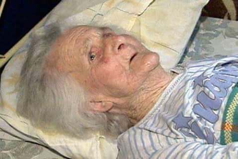 Une personne âgée alitée, tenant une main