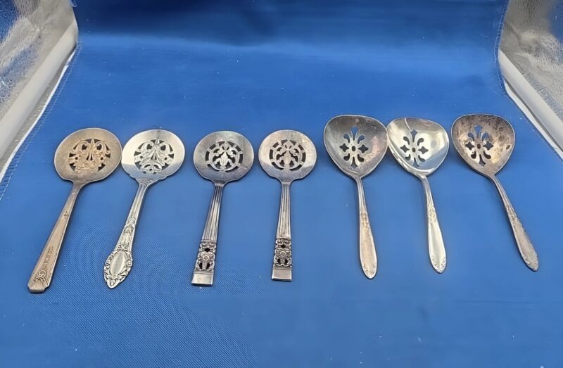 Cuillère à bonbons ancienne posée sur un tissu, avec des chocolats