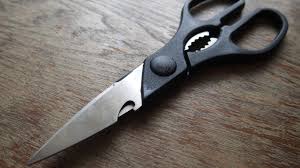 Détail de la partie dentelée entre les poignées de ciseaux de cuisine