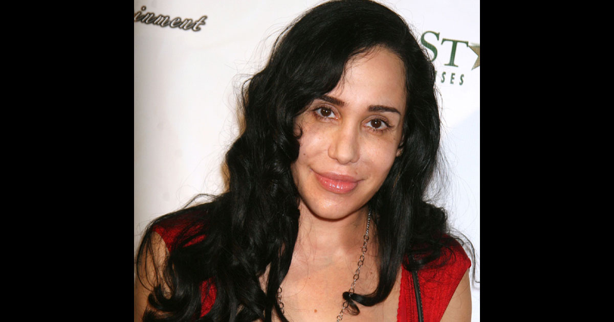 Nadia Suleman, souriante, dans son salon avec plusieurs de ses enfants