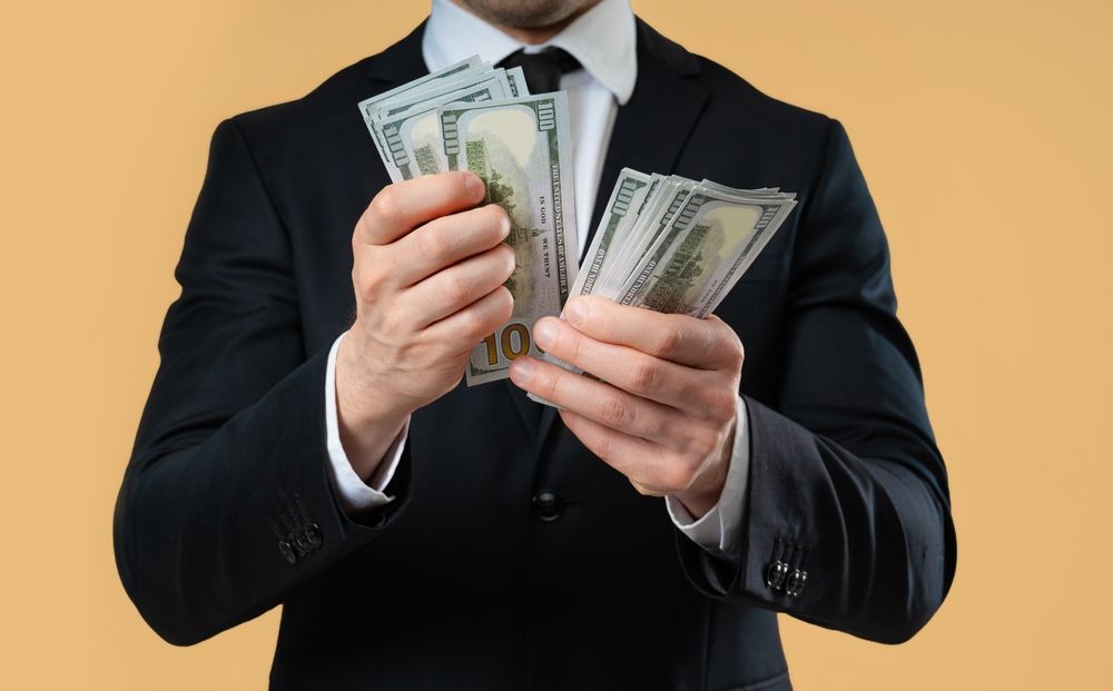 Femme souriante consultant ses finances sur une tablette, avec des graphiques à l'écran