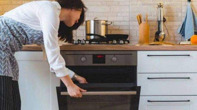 Casseroles et poêles empilées à côté d'un four